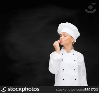 cooking, gesture and food concept - smiling female chef showing delicious gesture