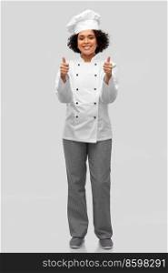 cooking, gesture and people concept - happy smiling female chef in white jacket showing thumbs up over grey background. smiling female chef in jacket showing thumbs up