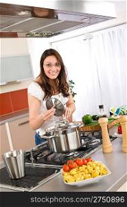 Cooking - Happy woman cook in modern kitchen with tortellini and vegetable