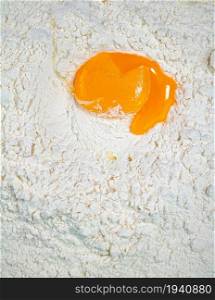 Cooking homemade cakes. Raw egg in a bunch of flour. On a white background.. Cooking homemade cakes. Raw egg in a bunch of flour.