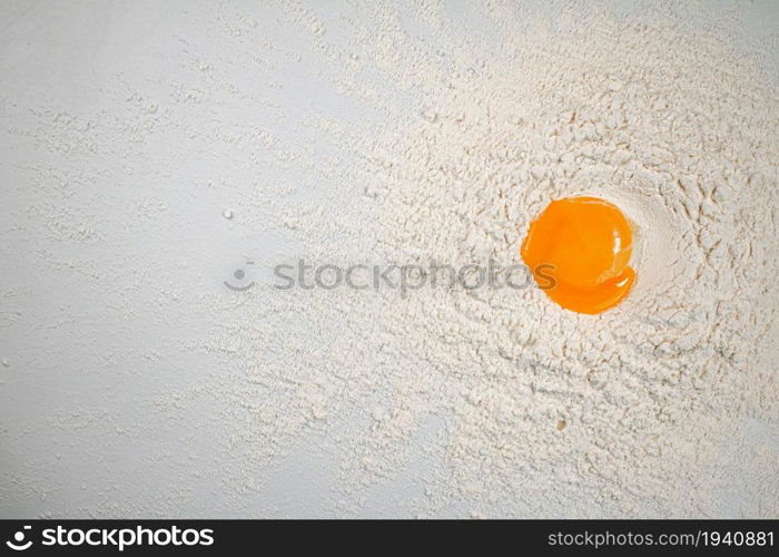 Cooking homemade cakes. Raw egg in a bunch of flour. On a white background.. Cooking homemade cakes. Raw egg in a bunch of flour.