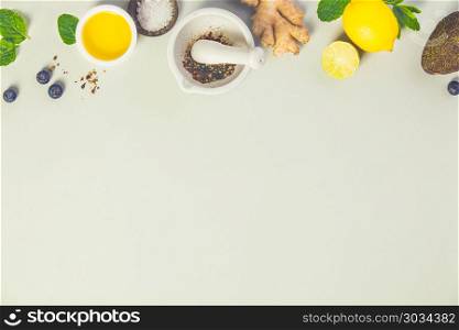 Cooking ingredients on grey concrete background: olive oil, herbs and spices. Vegan food, vegetarian and healthily cooking concept. Top view. Healthy cooking concept