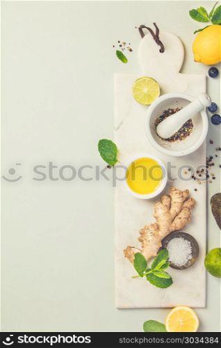 Cooking ingredients on grey concrete background: olive oil, herbs and spices. Vegan food, vegetarian and healthily cooking concept. Top view. Healthy cooking concept
