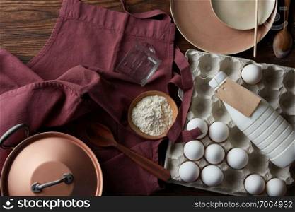 Cooking ingredients with utensils on wooden table. The process of cooking