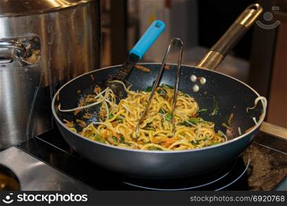 Cooking Italian Pasta with Vegetable Sauce inside Black Pan
