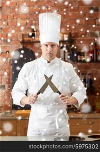 cooking, kitchenware and people concept - happy male chef cook with knife in restaurant kitchen over snow effect