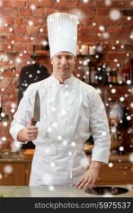 cooking, kitchenware and people concept - happy male chef cook with knife in restaurant kitchen over snow effect over snow effect