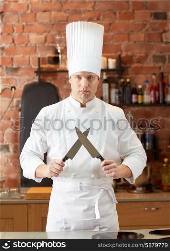 cooking, kitchenware and people concept - happy male chef cook with knife in restaurant kitchen
