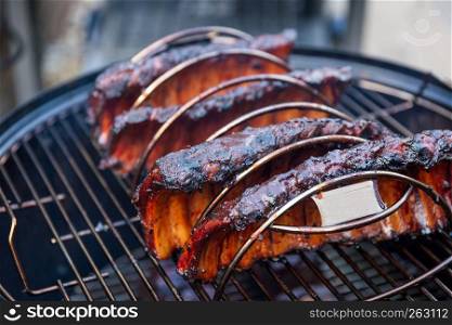 Cooking marinated baby back ribs on an outdoor barbecue