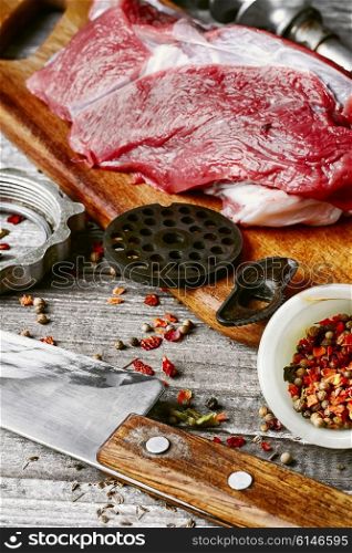 Cooking meat dish. Raw beef on chopping board and kitchen utensils