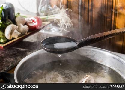 Cooking meat in vintage kitchen. Steam