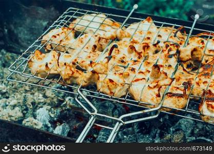 Cooking meat on fire. Fry meat on metal grid. Barbecue on nature for party.