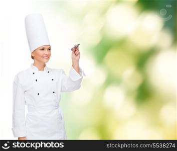 cooking, new techology , advertisement and food concept - smiling female chef with marker writing something on virtual screen