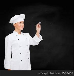 cooking, new techology , advertisement and food concept - smiling female chef, cook or baker with marker writing something on virtual screen