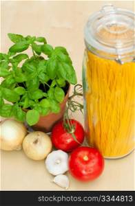 Cooking of Spaghetti - ingredients - pasta, basil, onion, garlic and tomatoes