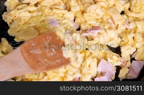 Cooking omelette with cheese and ham for breakfast. Closeup