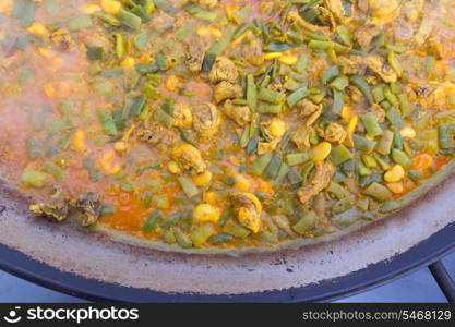 Cooking paella typical from Valencia Spain recipe with rice beans chicken and good hand