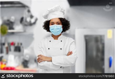 cooking, pandemic and health concept - happy smiling female chef in protective medical mask over restaurant kitchen background. female chef in medical mask and toque in kitchen