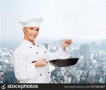 cooking, people and food concept - smiling female chef with pan and spoon tasting food over city background