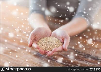 cooking, people and home concept - close up of female cupped hands with quinoa