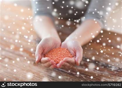 cooking, people and home concept - close up of woman emptying jar with red lentils in kitchen