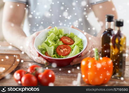 cooking, people, food, vegetarian and home concept - close of male hands holding bowl with salad