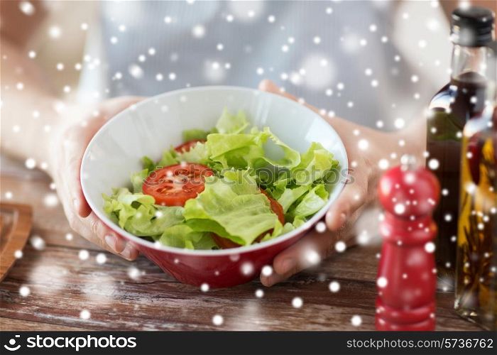 cooking, people, food, vegetarian and home concept - close of male hands holding bowl with salad