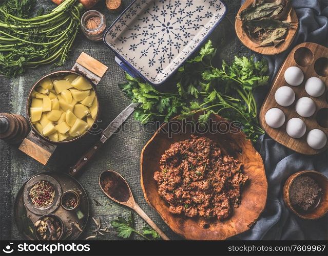Cooking preparation of potato meat casserole dish. Shepherd&rsquo;s pie ingredients. Rustic food. Vintage kitchen utensils. Flat lay. Home cuisine. Top view. Minced meat stuffing. Herbs and spices