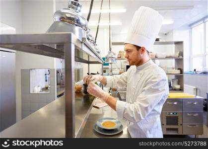 cooking, profession and people concept - happy male chef cook making food at restaurant kitchen. happy male chef cooking at restaurant kitchen