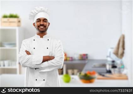 cooking, profession and people concept - happy male indian chef in toque over kitchen background. happy male indian chef in toque at kitchen