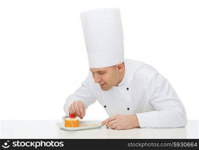 cooking, profession, haute cuisine, food and people concept - happy male chef cook decorating dessert