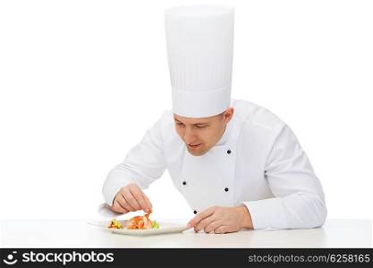 cooking, profession, haute cuisine, food and people concept - happy male chef cook decorating dish