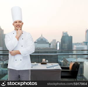 cooking, profession, inspiration and people concept - happy male chef cook thinking over city restaurant lounge background