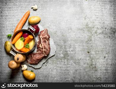 Cooking soup with vegetables and meat. On the stone table.. Cooking soup with vegetables and meat.
