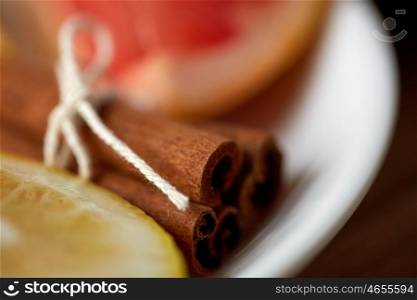 cooking, spice and ethnoscience concept - close up of cinnamon on plate