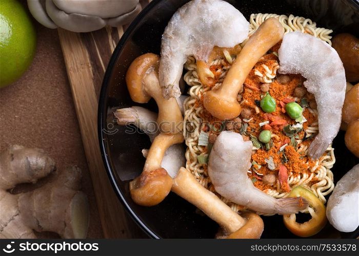 cooking spicy instant noodles soup with shrimps and mushrooms. flat lay. close up