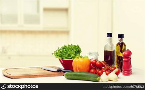 cooking, still life, food and healthy eating concept - fresh ripe vegetables, spices and kitchenware on table over kitchen background