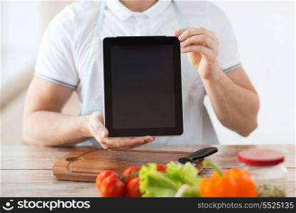 cooking, technology, advertising and home concept - close up of male hands holding tablet pc with blank black screen