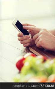 cooking, technology and home concept - closeup of male hand pointing finger to smartphone