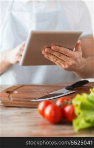 cooking, technology and home concept - closeup of man pointing finger to tablet pc computer