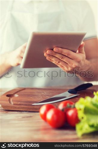 cooking, technology and home concept - closeup of man pointing finger to tablet pc computer