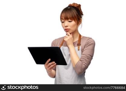 cooking, technology and people concept - happy smiling female chef or waitress in apron with tablet pc computer over white background. happy woman in apron with tablet pc computer