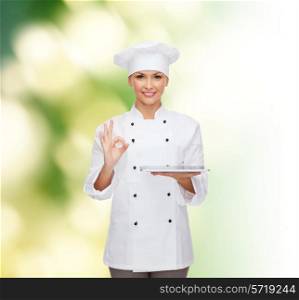 cooking, technology and people concept - smiling female chef, cook or baker with tablet pc computer showing ok gesture over green background