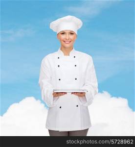 cooking, technology and people concept - smiling female chef, cook or baker with tablet pc computer over blue sky with cloud background