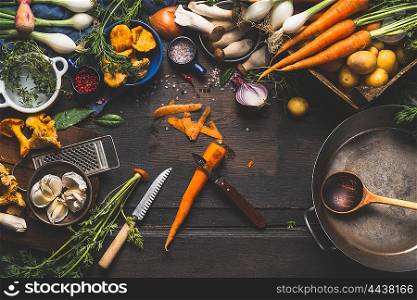 Cooking with forest mushrooms and vegetables ingredients and kitchen tools, preparation on dark rustic wooden table, top view