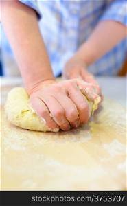 Cooking: woman hands kneading dough, close-up shot