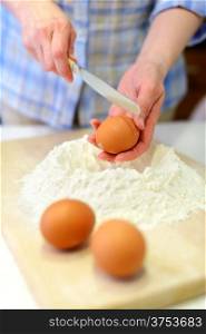 Cooking: woman making dough, adding eggs to flour