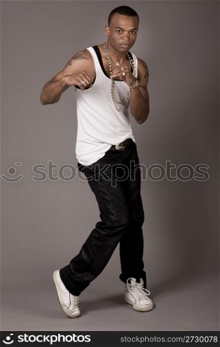 Cool african guy dancing on grey background