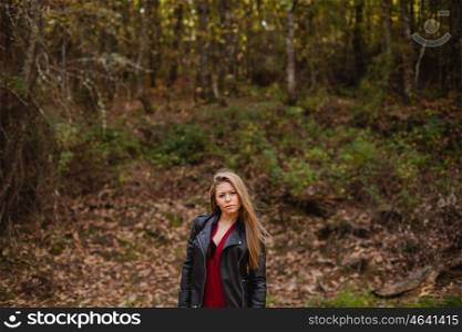 Cool blonde girl in the park on an autumn day