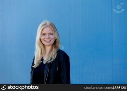 Cool blonde girl outdoor with a blue background